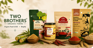 Product showcase image for Two Brothers Organic Farms, an organic food D2C Shopify brand. The display features packaged products including jaggery powder, cultured ghee, Byadgi chilli powder, and khapli multigrain flour, arranged with natural ingredients like sugarcane, red chilies, grains, and wheat. The brand name appears at the top with the label “Organic Food & D2C • Shopify,” highlighting the ecommerce case study context.